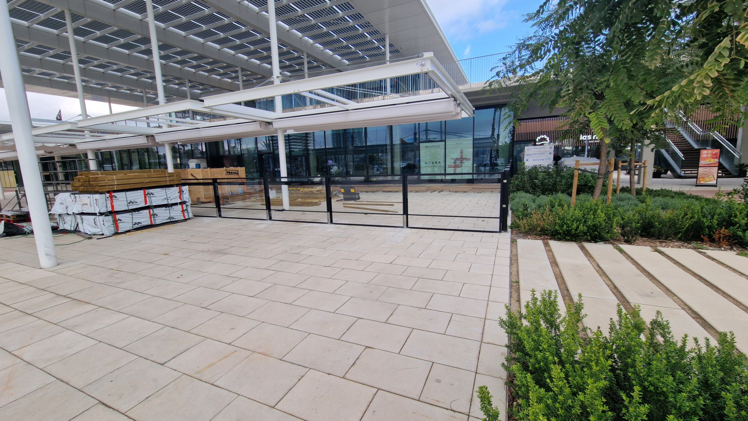 Zona exterior de un edificio moderno con un toldo retráctil parcialmente abierto