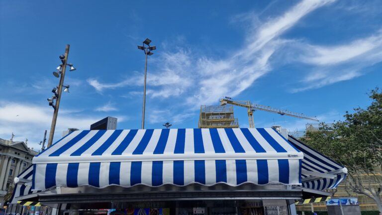 Primer plano detallado de un toldo con rayas azules y blancas, mostrando su estructura y diseño.