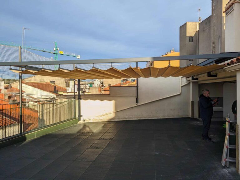 Toldo corredero de ondas instalado sobre estructura metálica en una terraza exterior en Martorell.