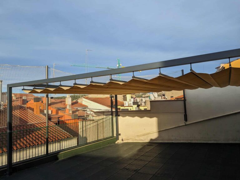 Pérgola metálica con toldo de ondas desplegable instalada en la terraza de la Escola La Mercè en Martorell.