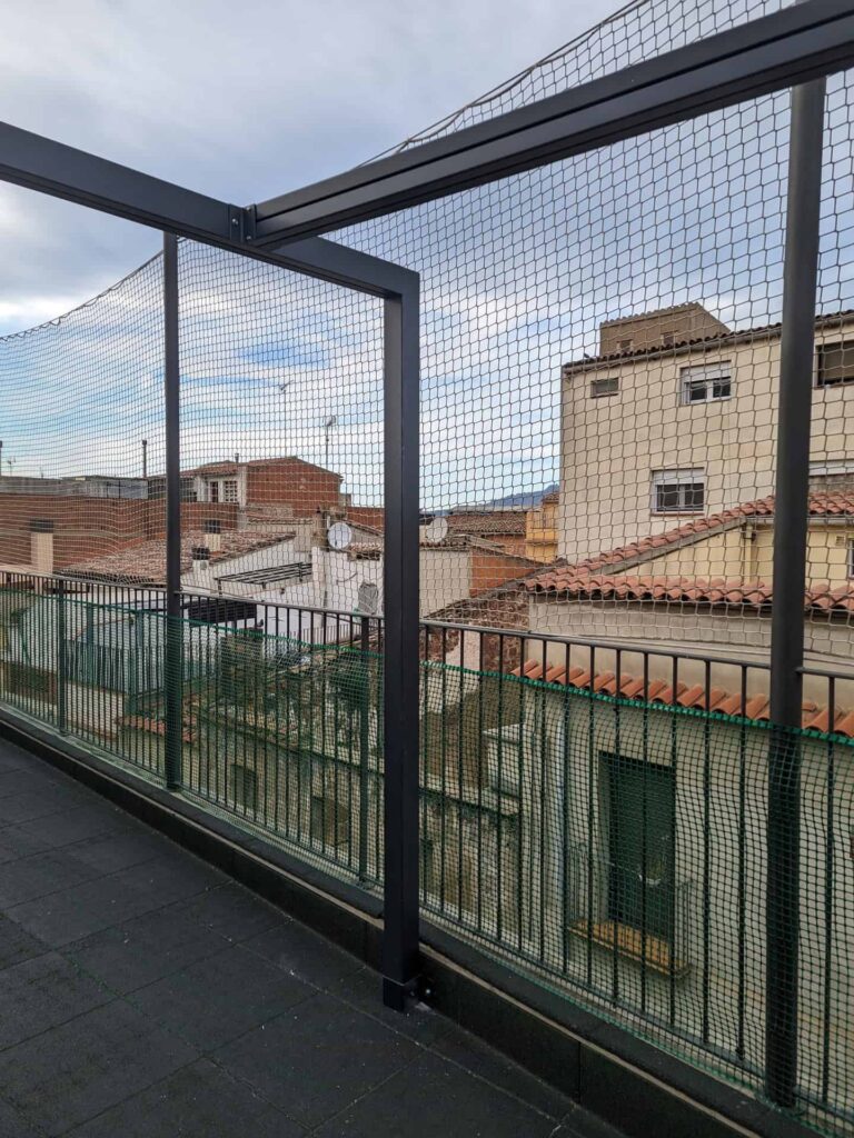 Estructura metálica con red de protección instalada sobre la barandilla de una terraza en la Escola La Mercè de Martorell.