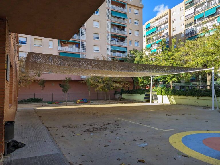 Estructura de sombra calada instalada sobre postes en el patio de la Escola Les Planes en La Llagosta.