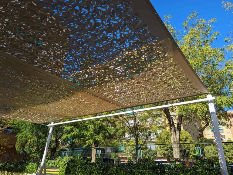 Plano inferior de estructura de sombra con lona calada y postes metálicos blancos en Escola Les Planes.