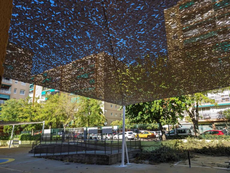 Vista inferior de estructura de sombra con malla troquelada instalada en el patio de la Escola Les Planes en La Llagosta.