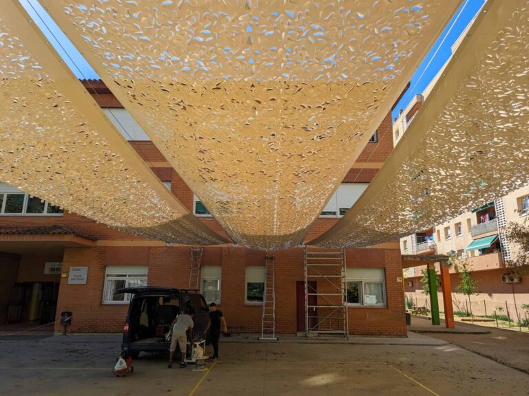 Instalación de velas de sombra microperforadas en el patio de la Escola Les Planes en La Llagosta.