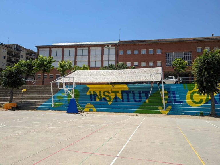 Estructura de sombra sobre la grada pintada en el patio deportivo del Institut El Cairat en Esparreguera.