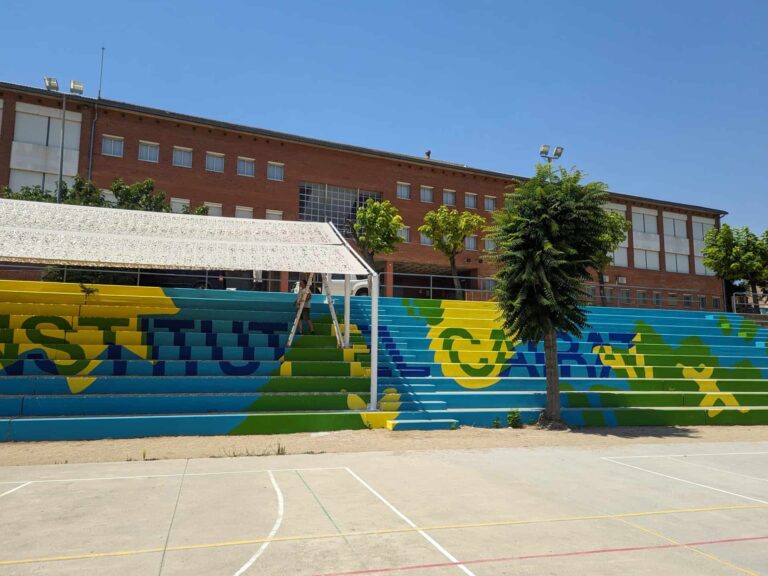 Estructura de sombra instalada sobre la grada pintada del patio en el Institut El Cairat en Esparreguera.