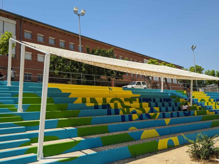 Estructura de sombra instalada sobre la grada pintada del patio del Institut El Cairat en Esparreguera.