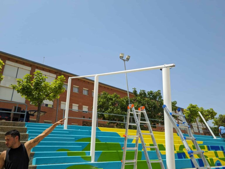 Instalación de estructura metálica blanca para sombra sobre gradas pintadas en el Institut El Cairat de Esparreguera.