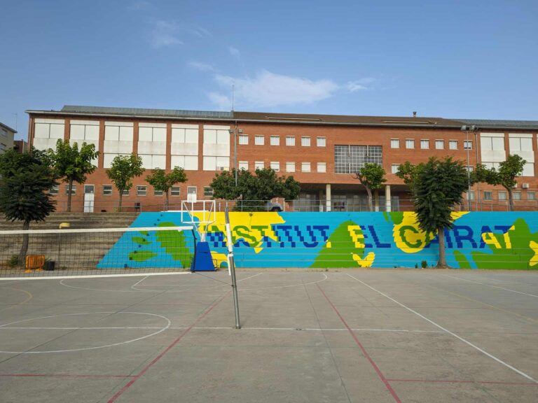 Pista deportiva y fachada del Institut El Cairat en Esparreguera con grada pintada.