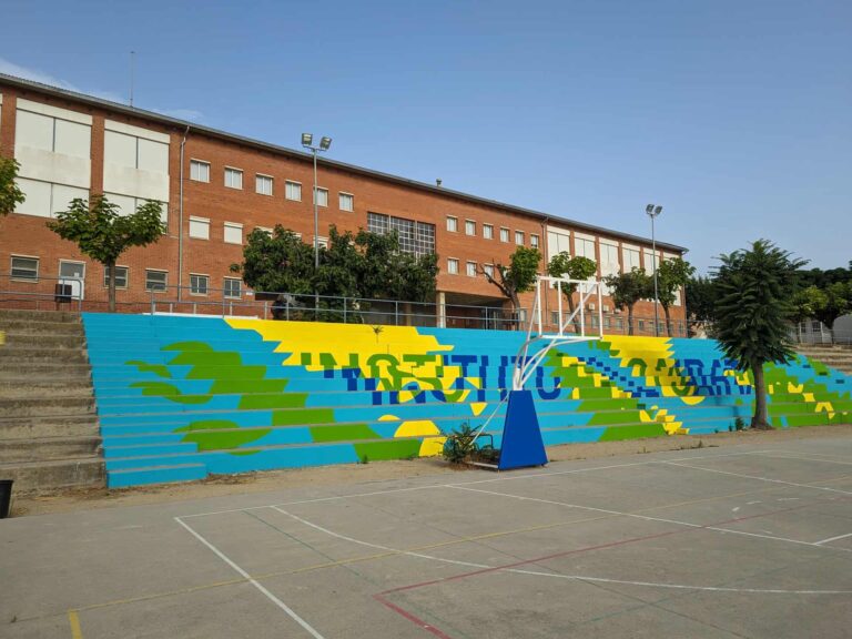 Patio y gradas con mural pintado frente al edificio del Institut El Cairat en Esparreguera.