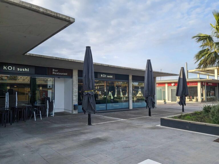 Parasoles de gran formato plegados en la terraza exterior del restaurante Koi Sushi en Port Premià.