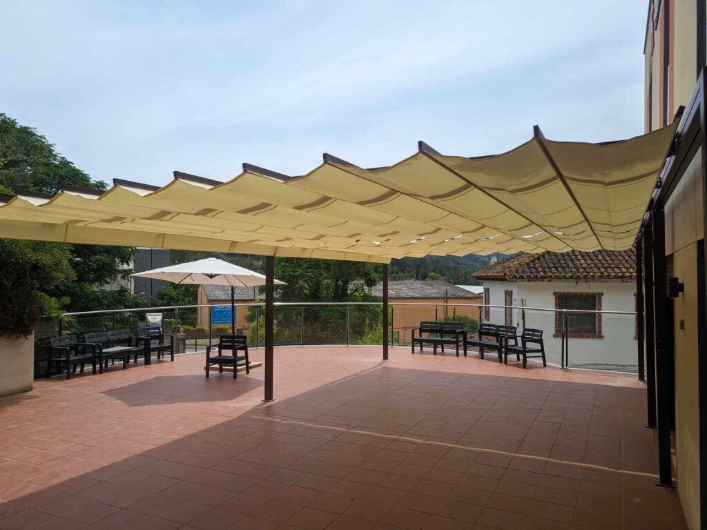 Pérgola con toldo textil de ondas instalada en la terraza exterior de la Residència Can Tarrida en Torrelles de Llobregat.